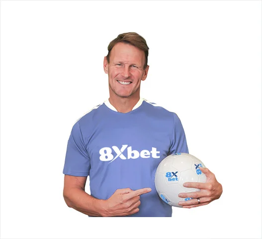 Cựu cầu thủ Teddy Sheringham mặc áo 8Xbet màu xanh, tay cầm quả bóng in logo 8Xbet
