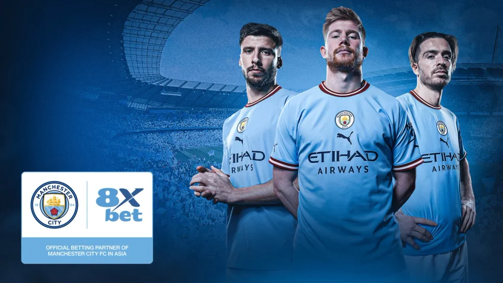 Ảnh công bố hợp tác 8xbet Man City: logo Manchester City và 8Xbet với dòng chữ Official Betting Partner of Manchester City FC in Asia, phía sau là ba cầu thủ Man City
